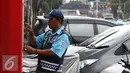 Petugas melakukan pembayaran pada mesin parkir meter di Jalan Falatehan, Jakarta, Selasa (1/11). Pemerintah sudah menggaungkan gerakan nasional nontunai (GNNT) kurang lebih sejak tiga tahun terakhir. (Liputan6.com/Immanuel Antonius)