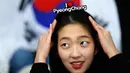 Penggemar wanita Korea Selatan menyesuaikan ikat kepalanya bertuliskan "I Love PyeongChang" saat menunggu pertandingan lomba skater 1.500 meter putra selama Olimpiade Musim Dingin 2018 di Gangneung Oval, Korea Selatan, (13/2). (AP Photo/John Locher)