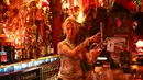 Lea, pemilik Klub Wild at Heart menyajikan minuman untuk tamunya, di Berlin, Jerman, (1/9).  Lea dan suaminya Uli, telah menjalankan kelab "Wild at Heart" selama lebih dari 20 tahun. (REUTERS/Hannibal Hanschke)