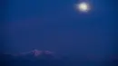 Fenomena supermoon yang sebagaian tertutup awan terlihat di atas Hutan Nasional Angeles, Los Angeles, Minggu (20/1). Supermoon terlihat dari sejumlah wilayah Amerika Utara dan Selatan, Eropa, dan Afrika Barat. (Robyn Beck / AFP)