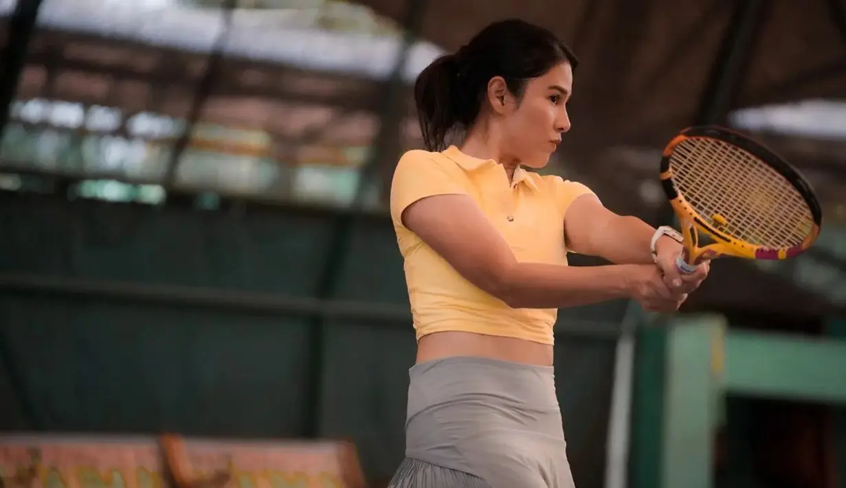 Sedikit lebih maskulin, Dian Sastrowardoyo memadukan polo shirt mustard dengan rok abu-abu [instagram/therealdianstr]