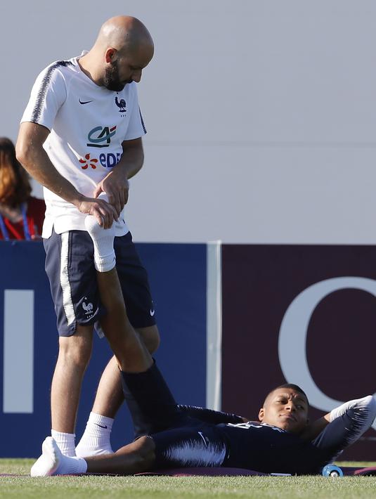 Kylian Mbappe menikmati terapi khusus saat sesi latihan tim Prancis di Glebovets, Rusia, (12/7/2018). Latihan tersebut sebagai persiapan Prancis melawan Kroasia pada Final Piala Dunia 2018. (AP/David Vincent)