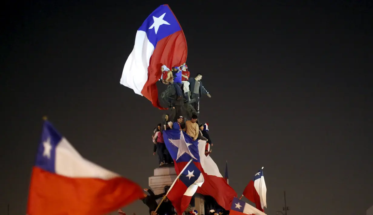 Sejumlah Suporter mengibarkan bendera nasional Chile merayakan kemenangan Chile atas Uruguay di Copa America 2015 di Santiago, Chile, (25/6/2015). Chile melaju ke semifinal usai mengalahkan Uruguay 1-0. (REUTERS/Pablo Sanhueza)