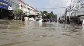 Warga terpaksa mendorong kendaraannya yang mogok saat melintasi banjir yang menggenangi Jalan Raya Cipondoh, Kota Tangerang, Banten, Selasa (8/7/2025). (Liputan6.com/Angga Yuniar)