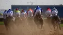 Para joki berlomba dalam lomba pacuan kuda Dubai Kahalya Classic yang menjadi bagian dalam Dubai World Cup di lintasan pacuan kuda Meydan, UEA, (26/3/2016). (AFP/Marwan Naamani)