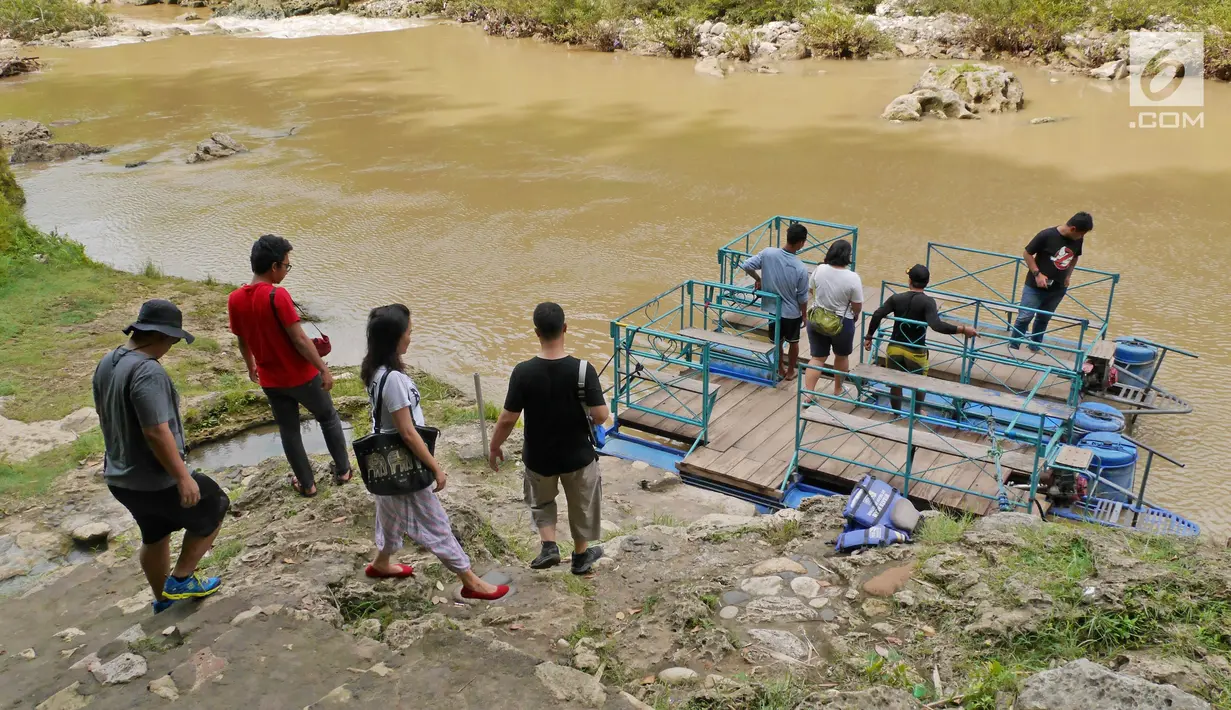 Wisatawan bersiap menaki rakit menuju objek wisata alam Air Terjun Sri Gethuk di Kabupaten Gunungkidul, Yogyakarta, Sabtu (11/11). Untuk bisa mencapai lokasi air terjun, wisatawan harus naik rakit. (Liputan6.com/Herman Zakharia)