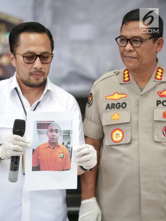 Wadir Reskrimum Polda Metro Jaya AKBP Ade Ary Syam Indradi (kiri) menunjukkan foto tersangka pengancam pemenggalan terhadap Presiden Joko Widodo atau Jokowi di Mainhall PMJ, Jakarta, Senin (13/5/2019). Tersangka ditangkap di rumah kerabatnya di kawasan Parung, Bogor. (Liputan6.com/Faizal Fanani)