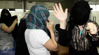Wanita asal Maroko menghindari sorotan kamera media saat berada di kantor Imigrasi, Jakarta, Kamis (11/6/2015). Dalam keterangannya, pihak Imigrasi mengamankan sejumlah wanita yang diduga PSK asal Maroko di Bogor. (Liputan6.com/Johan Tallo)