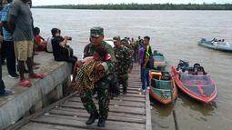 Satgas Kesehatan TNI memberi bantuan pengobatan wabah penyakit di Kabupaten Asmat, Papua, Jumat (19/1). Tim terdiri atas Pusat Kesehatan TNI dan TNI AD, Dinas Kesehatan TNI AL dan TNI AU bersama dinas kesehatan setempat. (LIputan6.com/Pool/Puspen TNI)