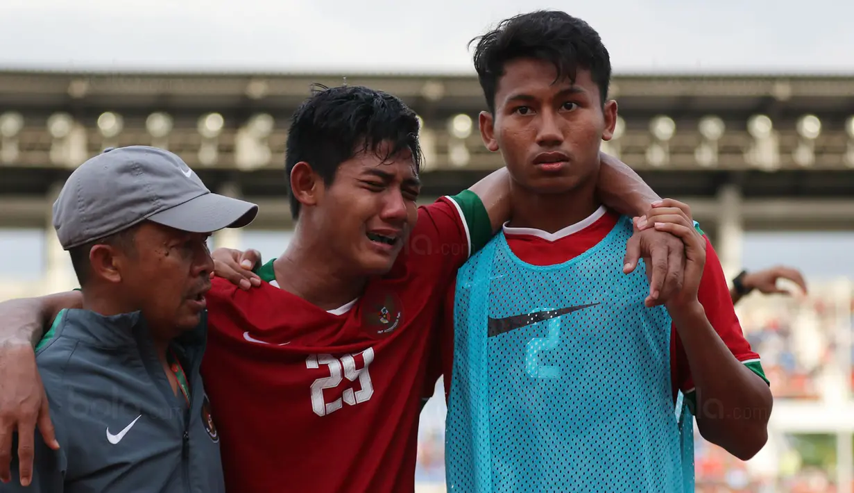 Bek Timnas Indonesia U-19, Firza Andika, menangis usai dikalahkan Thailand U-19 pada laga Piala AFF U-18 di Stadion Thuwunna, Yangon, Jumat (15/9/2017). Indonesia kalah adu penalti dari Thailand. (Bola.com/Yoppy Renato)