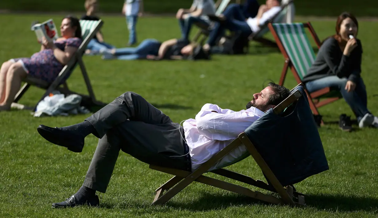 Seorang pria tampak bersantai menikmati sinar matahari di atas kursi di sebuah taman di London, Inggris, Rabu (4/5). Awal Mei, suhu udara hangat mulai menyelimuti kota London. (REUTERS/Neil Hall)