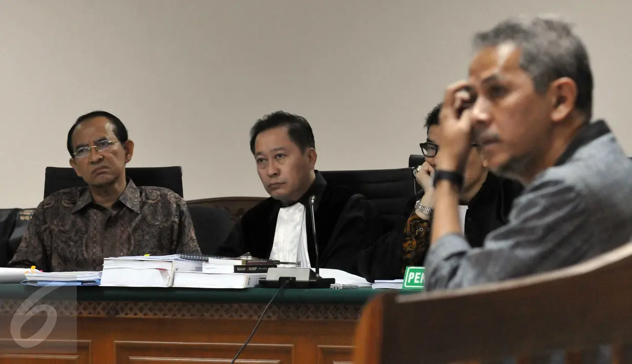 Suryadharma Ali (kiri) mendengarkan kesaksian Anggito Abimanyu di Pengadilan Tipikor, Jakarta, Senin (26/10/2015).  Anggito menyatakan PPP merupakan partai yang paling banyak mendapat jatah kuota haji. (Liputan6.com/Helmi Afandi)