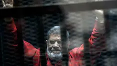 Mantan Presiden Mesir Mohammed Morsi mengenakan seragam merah yang menandakan dia telah dijatuhi hukuman mati saat menjalani sidang sementara di Akademi Kepolisian Nasional, Kairo, Mesir, 21 Juni 2015. Mohammed Morsi meninggal pada Senin 17 Juni 2019 waktu setempat. (AP Photo/Ahmed Omar, File)