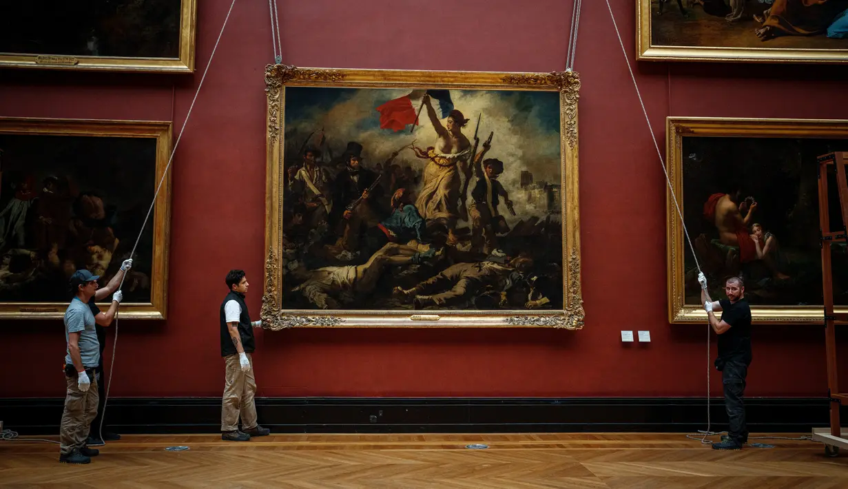Pekerja galeri memindahkan lukisan "Liberty Leading the People" karya Delacroix (1798-1863) dari dinding Museum Louvre menjelang pekerjaan restorasi yang dijadwalkan berlangsung hingga musim semi 2024 di Paris, 20 September 2023. (Dimitar DILKOFF / AFP)
