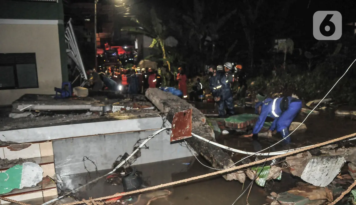 Petugas gabungan saat mengevakuasi reruntuhan pasca robohnya tembok bangunan akibat terjangan banjir di Madrasah Tsanawiyah (MTs) Negeri 19 di Jalan Pinang Kalijati, Pondok Labu, Cilandak, Jakarta Selatan, Kamis (6/10/2022). Peristiwa robohnya tembok sekolah bersamaan dengan hujan deras pada sore tadi tersebut diakibatkan oleh terjangan banjir yang menyebabkan tiga siswa tewas dan dua lainnya luka-luka. (merdeka.com/Iqbal S. Nugroho)