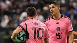 Pemain Inter Miami, Luis Suarez (kanan) berbincang dengan rekannya, Lionel Messi saat laga persahabatan melawan Al-Hilal yang berlangsung di Kingdom Arena Stadium, Riyadh, Arab Saudi, Selasa (30/01/2024) WIB. Suarez mencetak gol pada menit ke-34. (AFP/Fayez Nureldine)