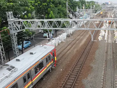 KRL melintas di jalur dwiganda atau double-double track (DDT) kawasan Jatinegara, Jakarta, Jumat (12/4). DDT segmen Jatinegara-Cakung mulai digunakan pada hari ini. (Liputan6.com/Herman Zakharia)