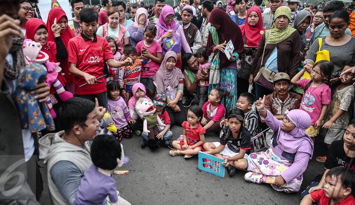 Gerakan Para Pendongeng untuk Kemanusiaan (GePPuK) menggelar aksi mendongeng saat Car Free Day di Bundaran HI, Jakarta, Minggu (5/6). Kampanye ini agar anak bisa menghindari kemungkinan kejahatan seksual terhadap diri mereka. (Liputan6.com/Faizal Fanani)