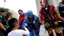 Petugas pembersih kaca berkostum superhero menyapa seorang anak di luar rumah sakit anak-anak di Guadalupe, Meksiko, 30 April 2019. Mereka bergelantungan di luar jendela dengan mengenakan kostum superhero untuk menghibur anak- anak yang sedang sakit. (REUTERS/Daniel Becerril)