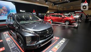 Model berdiri samping mobil Mitsubishi New Xpander pada JAW 2022 di booth Mitsubishi Motors JCC, Jakarta, Selasa (15/3/2022). MMKSI menghadirkan line-up unggulan Mitsubishi Motors terdiri dari New Xpander, New Xpander Cross, Pajero Sport, Outlander PHEV dan Triton. (Liputan6.com/Fery Pradolo)