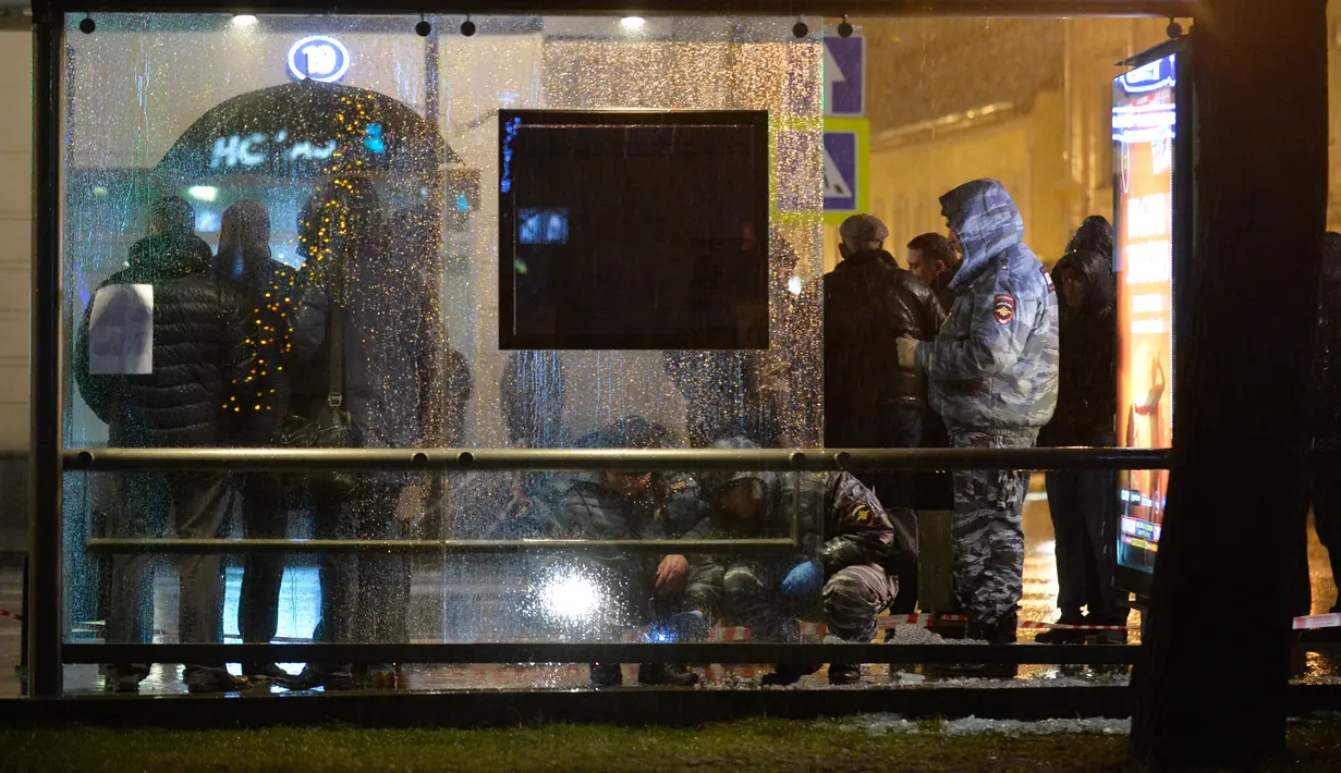 Polisi memeriksa sebuah halte bus yang rusak akibat terkena ledakan di Moskow, Rusia, Senin (7/12). Tiga orang luka terkena pecahan kaca. Bahan peledak diperkirakan dilemparkan dari mobil atau bangunan perumahan di dekatnya. (AFP/NATALIA Kolesnikova)