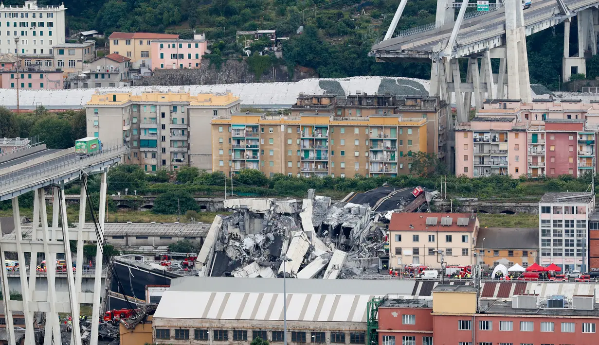 Sebuah truk berada di atas jembatan Morandi, dekat dengan bagian jalan layang yang runtuh, di Genoa, italia, Selasa (14/8). Jembatan ini memiliki tinggi 50 meter, termasuk menara penyangga, runtuh ketika 35 kendaraan berada di jembatan (AP/Antonio Calanni