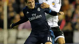 Gelandang Real Madrid, Mateo Kovacic (kiri) berusaha mengontrol bola dari kawalan gelandang Valencia, Salvador Danilo pada lanjutan liga Spanyol di stadion Mestalla, (3/1/2015). Real Madrid bermain imbang dengan Valencia dengan skor 2-2. (AFP/JOSE JORDAN)