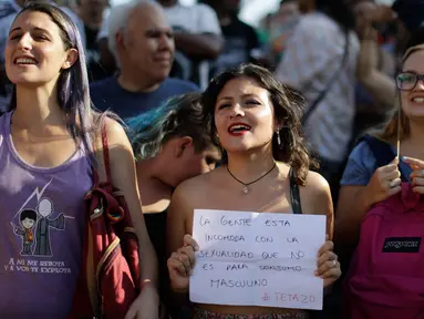 Seorang wanita memegang tulisan bernada protes saat unjuk rasa di Ibu Kota Argentina, Buenos Aires, Selasa (7/1). Aksi itu sebagai bentuk protes atas kekerasan yang dilakukan aparat kepolisian terhadap perempuan tanpa bra. (AP Photo/Natacha Pisarenko)