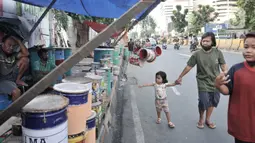 Pejalan kaki melintas di depan penjual beduk di kawasan Tanah Abang, Jakarta, Selasa (19/5/2020). Pedagang mengaku memasuki seminggu jelang Lebaran penjualan beduk hanya mencapai puluhan, berbeda jauh dengan tahun lalu yang mampu menjual hingga ratusan beduk. (merdeka.com/Iqbal Nugroho)