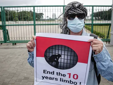 Pengungsi Afghanistan mengangkat poster saat berunjuk rasa di kawasan Monas, Jakarta, Rabu (19/1/2022). Mereka menuntut kejelasan untuk berangkat ke negara ketiga setelah lama tinggal di pengungsian. (Liputan6.com/Faizal Fanani)