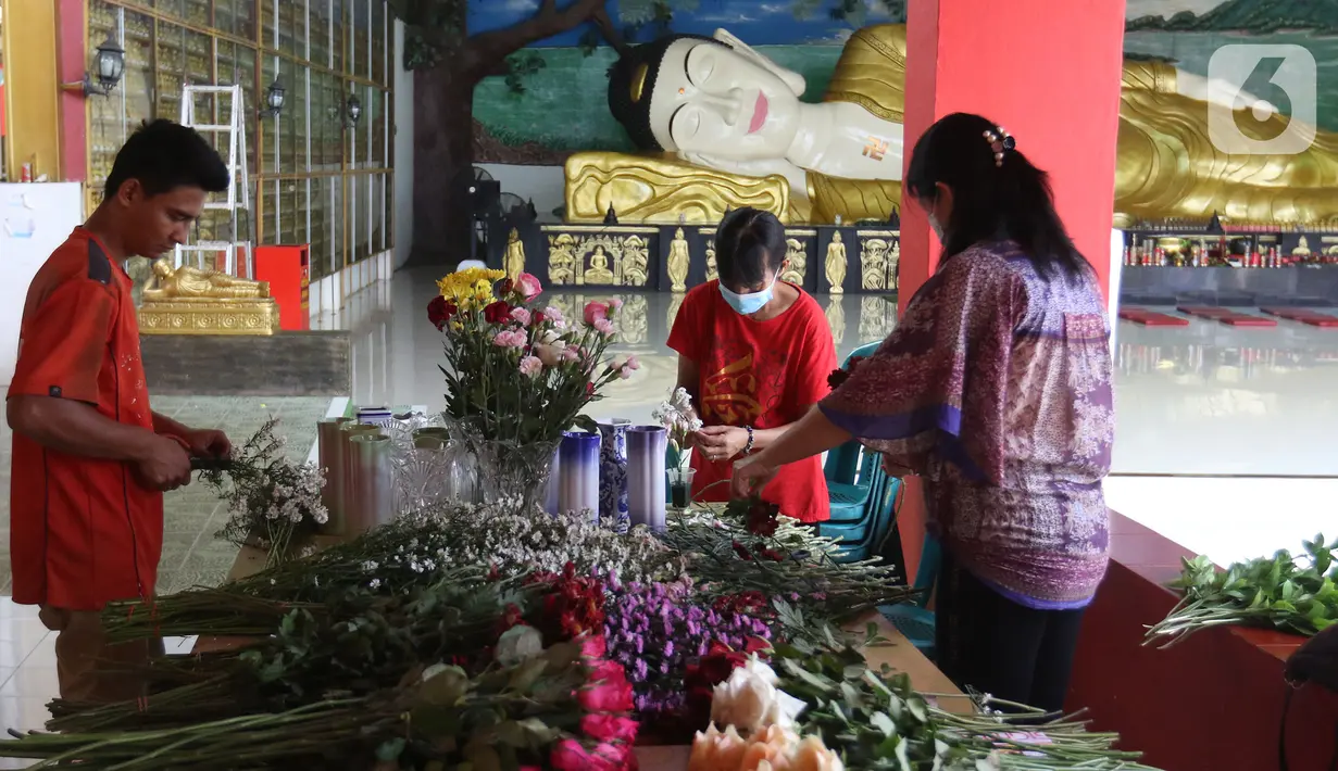 Pekerja merangkai bunga di Vihara Buddha Dharma dan 8 Pho Sat, Desa Tonjong, Tajurhalang, Kabupaten Bogor, Selasa (25/5/2021). Vihara itu mulai dihias dan dibersihkan untuk memberi kenyamanan bagi umat Budha yang akan beribadah saat peringatan Hari Raya Waisak. (Liputan6.com/Herman Zakharia)