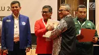Sekjen PDIP Hasto Kristiyanto menerima berita acara hasil rekapitulasi dari Ketua KPU Arief Budiman saat Rekapitulasi Nasional Hasil Verifikasi Peserta Pemilu 2019, Jakarta (17/2). (Liputan6.com/JohanTallo)