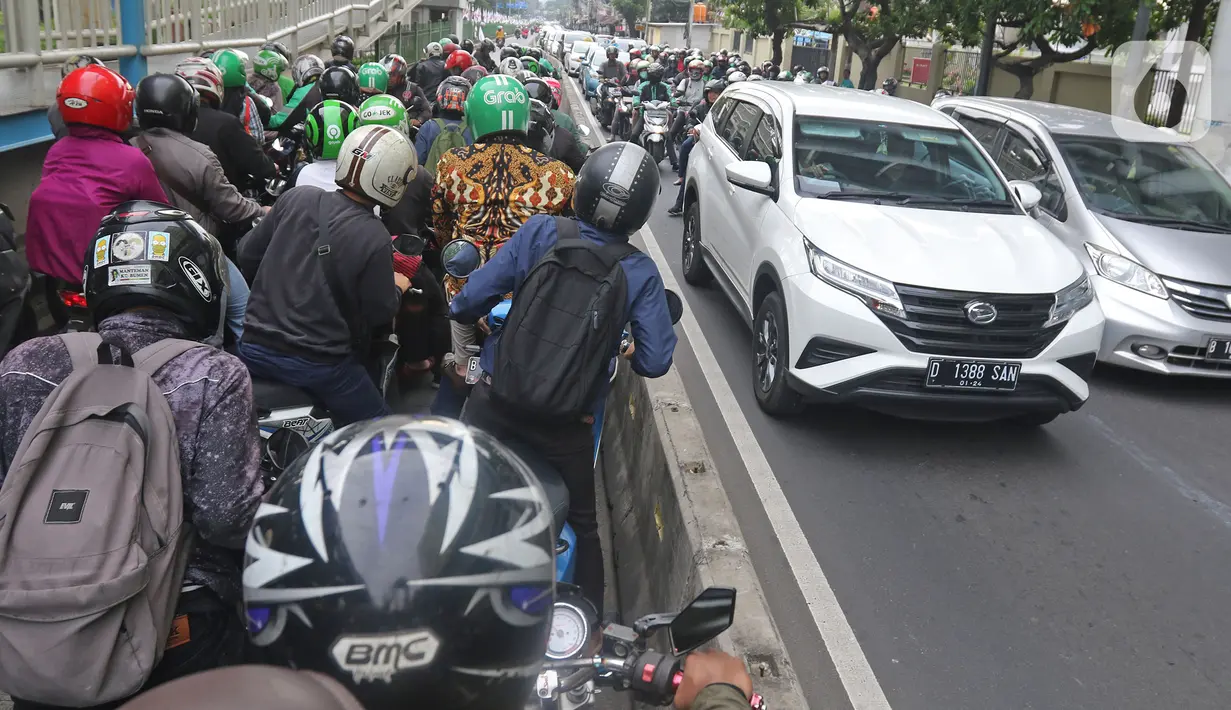 Sejumlah pengendara sepeda motor mencoba menghindar saat polisi menggelar razia bagi penerobos jalur Transjakarta di Jalan Sultan Agung, Manggarai, Jakarta, Rabu (12/2/2020). Pengendara kerap melintasi jalur Transjakarta untuk menghindari kemacetan lalu lintas. (Liputan6.com/Herman Zakharia)
