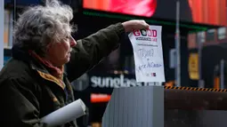 Seorang perempuan menghancurkan kertas berisi kenangan menyulitkan selama kegiatan Good Riddance Day ke-13 tahunan di Times Square, New York, 28 Desember 2019. Kegiatan menjelang tahun baru tersebut menjadi tradisi untuk menghapus kenangan buruk selama satu tahun. (Kena Betancur / AFP)
