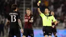 Wasit memberikan bek AC Milan, Alessio Romagnoli, kartu kuning saat menjatuhkan pemain Juventus pada laga Piala Super Italia 2016. Laga yang berlangsung keras ini membuat wasit mengeluarkan lima kartu kuning. (Reuters/Ibraheem Al Omari)