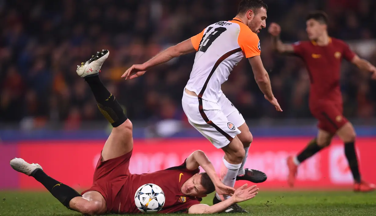 Striker AS Roma, Edin Dzeko berebut bola dengan bek Shakhtar Donetsk, Ivan Ordets pada leg kedua 16 besar Liga Champions 2017-2018  di Stadion Olimpico, Rabu (14/3). AS Roma melaju ke perempatfinal usai menang dengan skor 1-0. (Filippo MONTEFORTE/AFP)