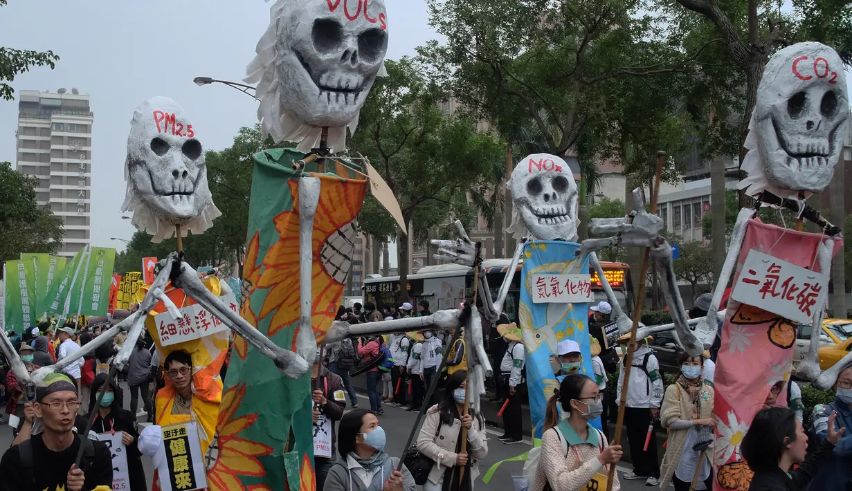 Demonstran memakai masker membawa properti tengkorak selama unjuk rasa menuntut pemerintah Taiwan dalam pengurangan polusi udara di Taipei (26/12). Ratusan warga berbaris di jalan-jalan memprotes kebijakan energi pemerintah. (AFP PHOTO/Sam Yeh)