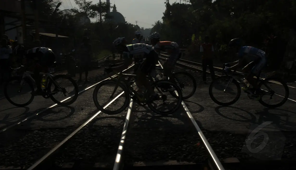 Beberapa pebalap melitasi rel kereta yang masuk dalam jalur lintasan etape 2 Internasional Tour De Banyuwangi Ijen, (17/10/2014). (Liputan6.com/Helmi Fithriansyah)