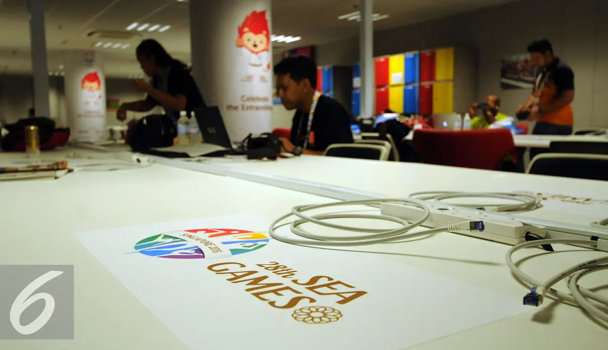 Sejumlah pewarta mulai bekerja di Main Press Centre (MPC) yang terletak di Gate 18 National Stadium Singapura, Senin (1/6/2015). Meja kerja para wartawan juga dilengkapi kabel data dan jaringan nirkabel. (Liputan6.com/Helmi Fithriansyah)