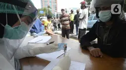 Petugas medis mendata pengendara yang terjaring razia masker di Jalan Panjang, Kedoya, Jakarta Barat, Senin (2812/2020). Pengendara yang tidak mengenakan masker langsung menjalani rapid test antigen gratis untuk mencegah penularan COVID-19. (merdeka.com/Dwi Narwoko)