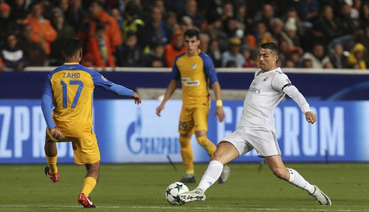 Pemain Real Madrid, Cristiano Ronaldo (kanan) mengecoh pemain APOEL, Ghayas Zahid pada laga Liga Champions grup H di GSP stadium, Nicosia, (21/11/2017). Madrid menang 6-0. (AP/Petros Karadjias)