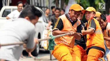 Petugas PPSU Kelurahan Kebon Sirih saat mengikuti lomba tarik tambang di kawasan Jalan Jaksa, Jakarta, Kamis (17/8). Lomba diadakan untuk memeriahkan HUT RI ke-72. (Liputan6.com/Helmi Fithriansyah)