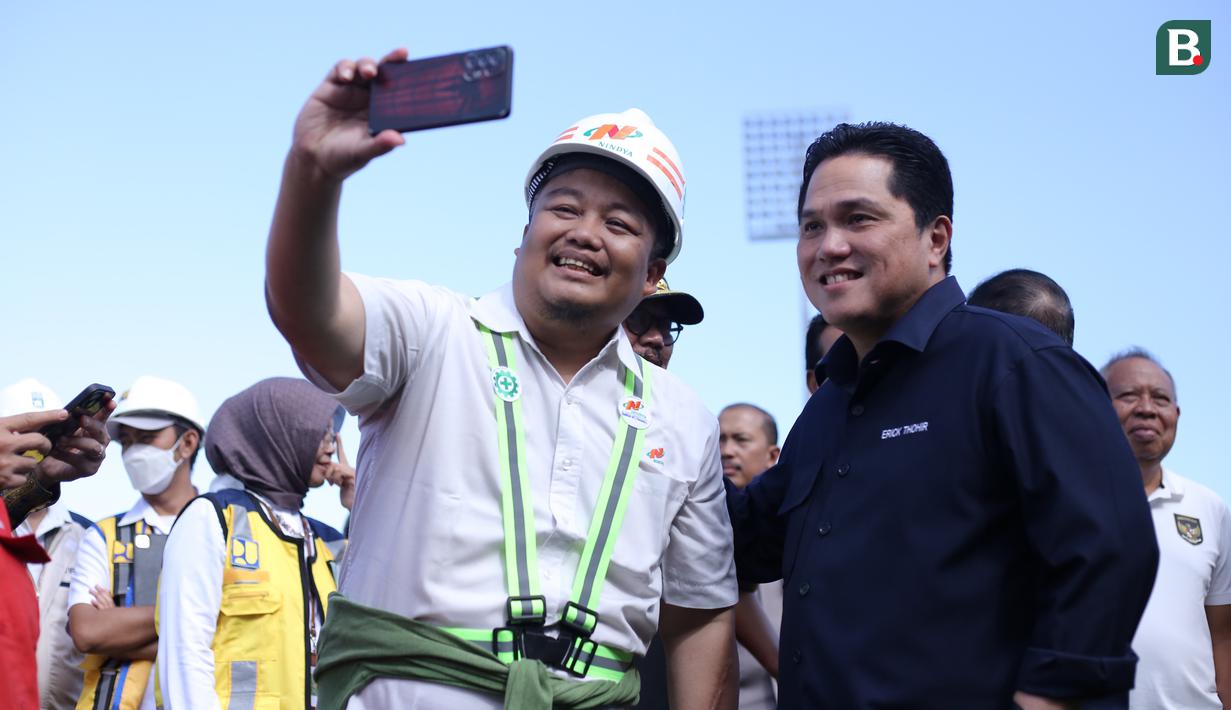 Ketua Umum PSSI, Erick Thohir berswafoto dengan salah seorang pekerja saat berkunjung ke Stadion Kapten I Wayan Dipta, Gianyar, Minggu (12/3/2023) dalam rangka meninjau kesiapan 6 venue Piala Dunia U-20 2023. (Bola.com/Alit Binawan)
