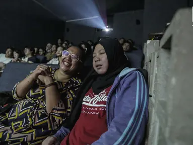 Sejumlah penyandang tunanetra mendengarkan relawan bisik saat menyaksikan film di Bioskop Bisik di Pavilliun 28, Jakarta, Minggu (14/1).  Kini, menonton bioskop bukan menjadi hal mustahil lagi bagi penyandang tunanetra. (Liputan6.com/Faizal Fanani)