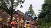 Foto selebaran yang diambil pada 16 Juli 2025 dan dirilis pada 17 Juli 2025 oleh Dinas Pemadam Kebakaran Gyeonggi-do ini menunjukkan anggota tim penyelamat yang sedang mencari orang-orang yang hilang setelah dinding penahan setinggi 10 meter dari jembatan penyeberangan runtuh ke jalan saat hujan lebat di Osan, Korea Selatan. (Handout/Gyeonggi-do Fire Services/AFP)