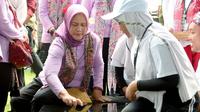Iriana Jokowi saat menjajal permainan bekel di sela kunjungan ke Banyuwangi. (Hermawan/Liputan6.com)