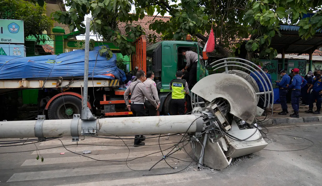 Polisi bekerja di lokasi kecelakaan lalu lintas di Bekasi, Indonesia, Rabu (31/8/2022). Sebuah truk kontainer menghantam halte dekat sekolah. (AP Photo/Achmad Ibrahim)