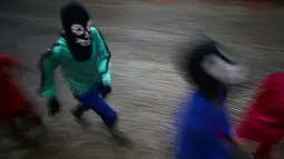 Sejumlah anak-anak mengenakan kostum dan topeng ikut memeriahkan festival "Cavalhadas" di Pirenopolis, Brasil (20/5). (AP Photo/Eraldo Peres)