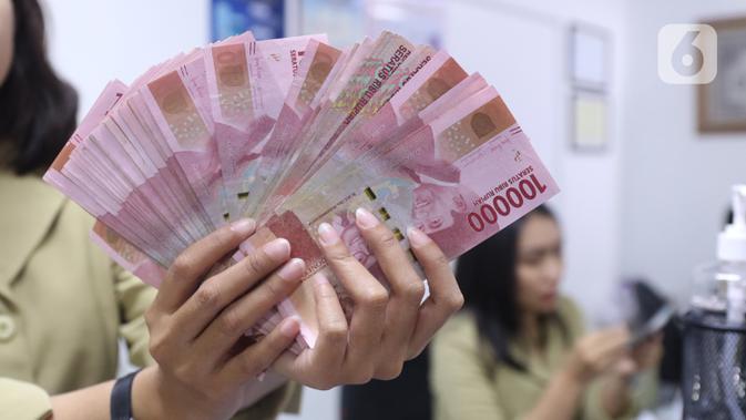 Pegawai menunjukkan mata uang rupiah di penukaran uang di Jakarta. (Liputan6.com/Angga Yuniar)