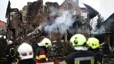 Para petugas penyelamat Ukraina berdiri di samping sebuah rumah yang rusak parah setelah serangan udara di Sofiivska Borshchagivka, wilayah Kyiv pada Minggu 22 Februari 2026. Rusia kembali melancarkan serangan besar-besaran menggunakan rudal dan pesawat nirawak (drone) ke wilayah pinggiran kota Kyiv. (Henry NICHOLLS/AFP)